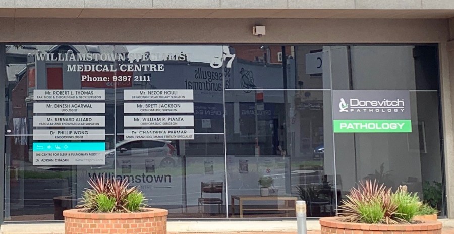 The glass shopfront of Williamstown Specialist Medical Centre at 87 Ferguson Street, with a board listing visiting specialists and a Dorevitch Pathology sign. The entrance is level with the footpath.